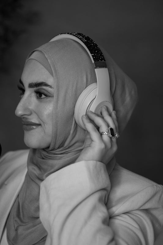 Woman wearing headphones and hijab in a black and white photo