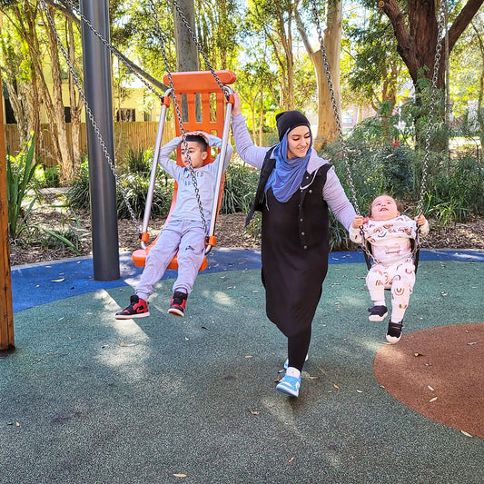 two kids in a swing with mother