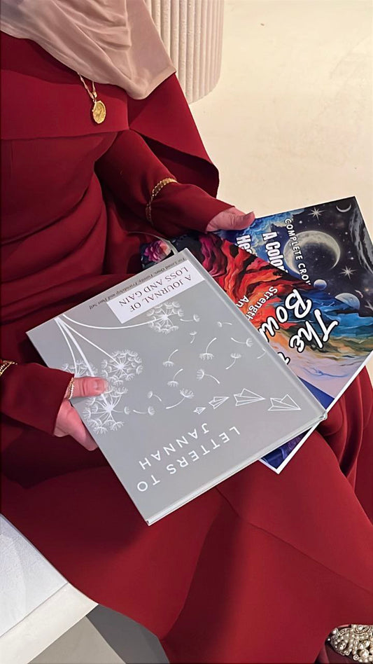 Person holding a book titled 'Letters to Fanny' with other books on a surface.