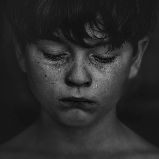 Hands covering a face in shadow representing the weight of shame and the healing available through therapy in NSW Sydney