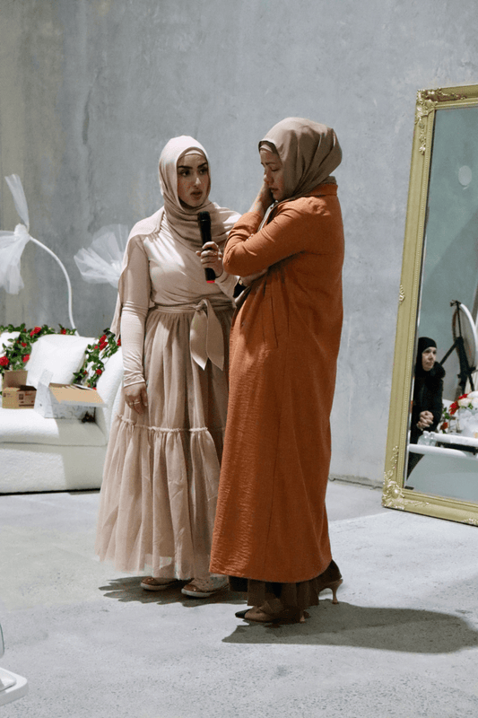 Two individuals engaged in a healing session, standing in a well-lit room with a large mirror and decor.