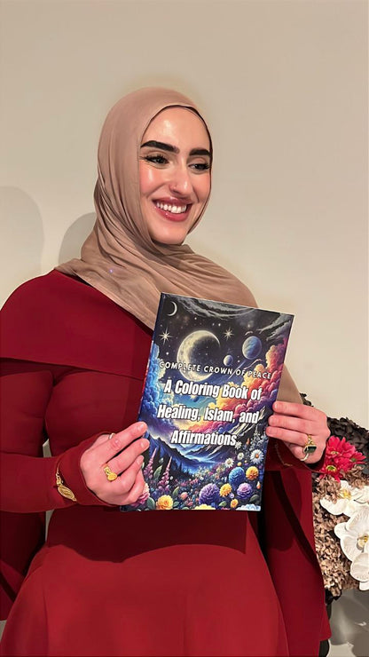Woman holding a coloring book titled 'A Coloring Book of Healing, Islam, and Affirmations' against a neutral background.
